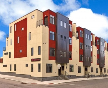 Exterior of The Flats at Brewerytown apartment building in Philadelphia on a sunny day with blue skies.